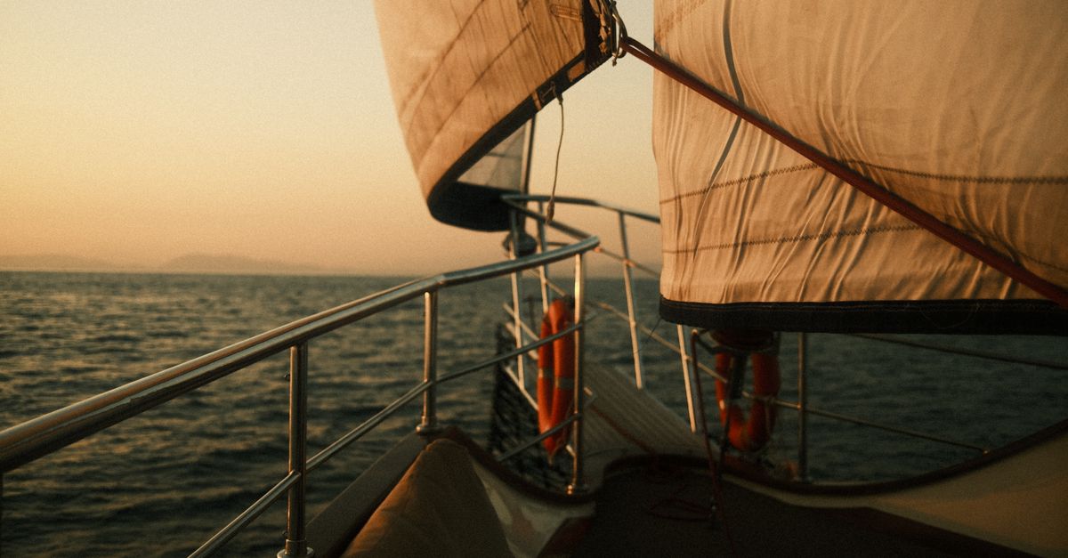 A serene sunset view from a sailboat on the open sea, capturing the beauty of sailing.